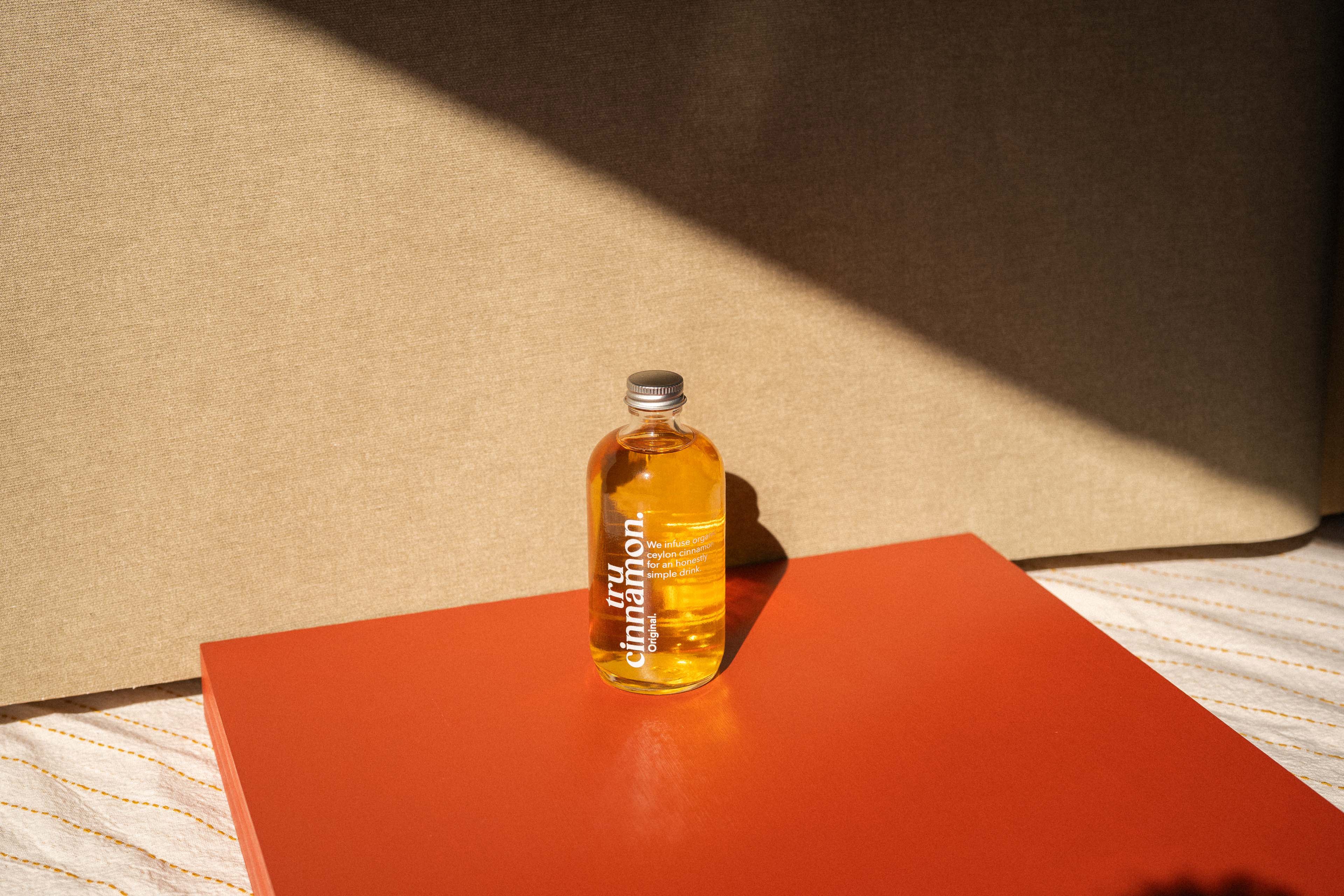 Bottle of Sunflower oil on a red surface with a beige background